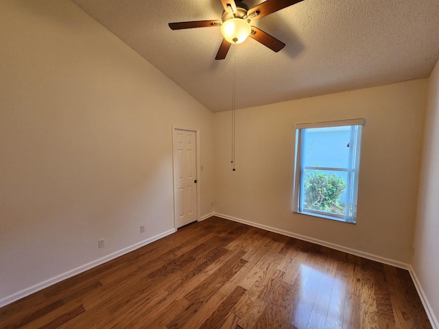 unfurnished room with a textured ceiling, ceiling fan, dark wood-type flooring, and vaulted ceiling