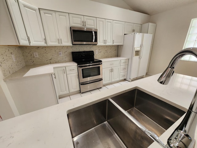 kitchen with decorative backsplash, white cabinetry, sink, and appliances with stainless steel finishes