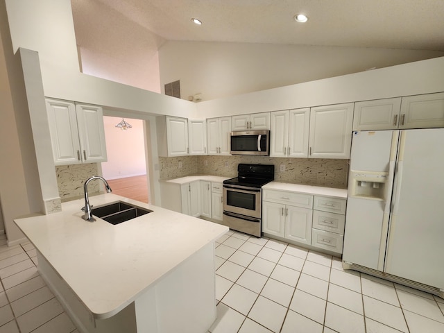 kitchen featuring sink, tasteful backsplash, kitchen peninsula, white cabinets, and appliances with stainless steel finishes