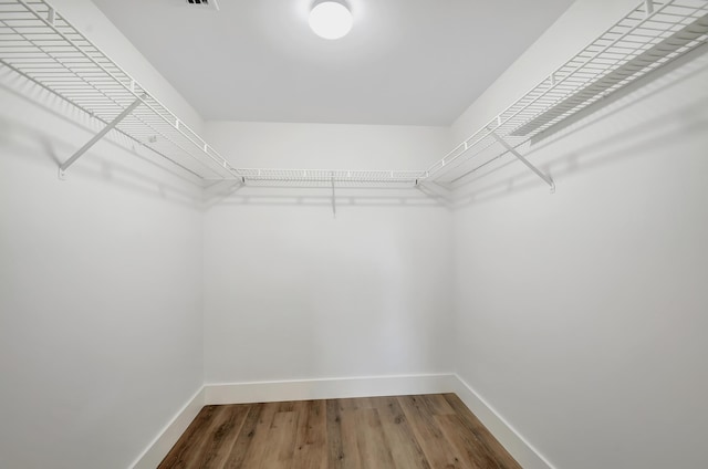 walk in closet with hardwood / wood-style floors