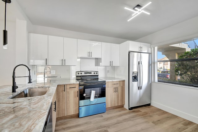 kitchen featuring light stone counters, sink, white cabinets, and stainless steel appliances