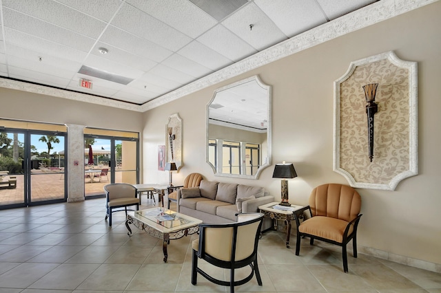 tiled living room featuring a drop ceiling