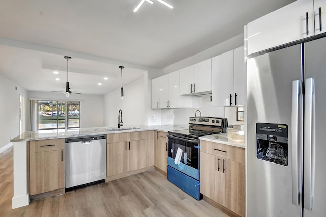 kitchen with white cabinets, sink, appliances with stainless steel finishes, decorative light fixtures, and kitchen peninsula