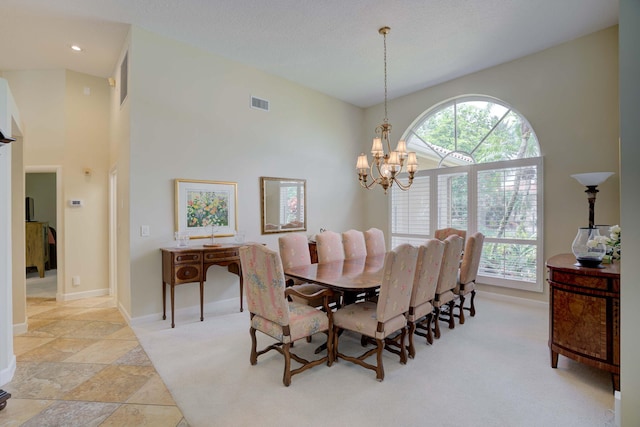 carpeted dining space featuring a notable chandelier