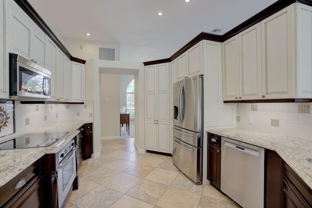 kitchen featuring white cabinetry, light stone countertops, stainless steel appliances, and tasteful backsplash