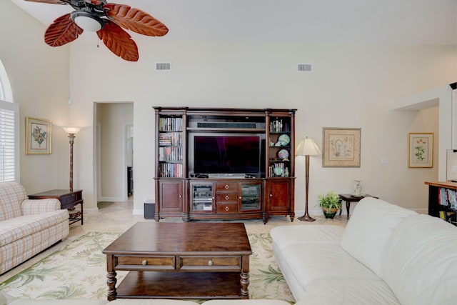 living room with ceiling fan and a towering ceiling