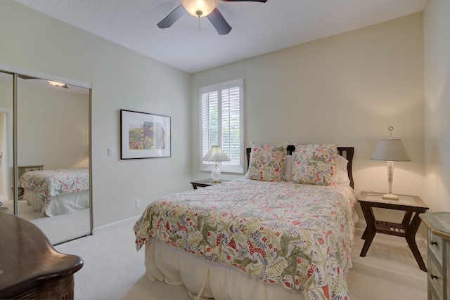 carpeted bedroom featuring ceiling fan, a textured ceiling, and a closet