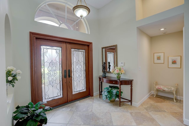 foyer featuring a towering ceiling and french doors