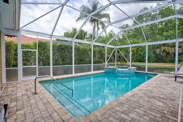 view of pool with glass enclosure, an in ground hot tub, and a patio area