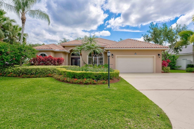 mediterranean / spanish house featuring a front yard and a garage