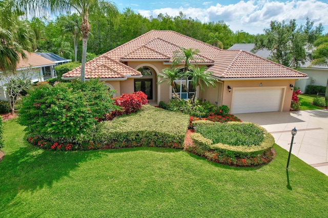 mediterranean / spanish-style home featuring a garage and a front yard