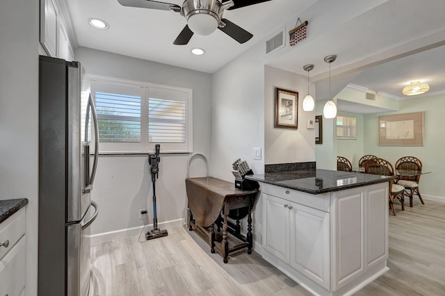 kitchen featuring stainless steel fridge, light hardwood / wood-style floors, white cabinetry, and pendant lighting