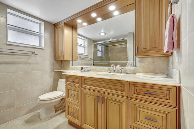 bathroom with vanity, toilet, tile walls, and a shower with shower door