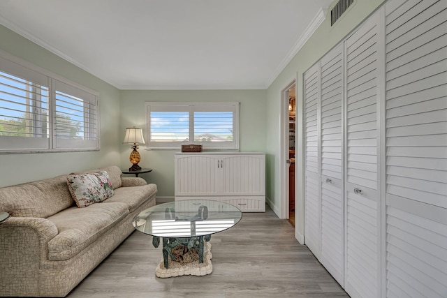 living room featuring crown molding and light hardwood / wood-style floors