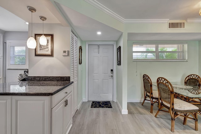 entryway with light hardwood / wood-style flooring and ornamental molding