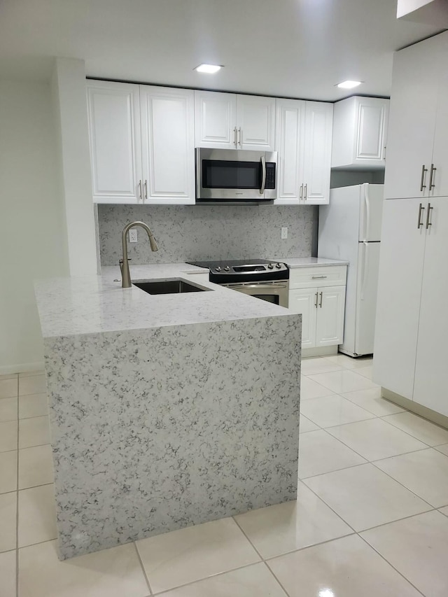 kitchen with white cabinets, sink, light tile patterned floors, and stainless steel appliances