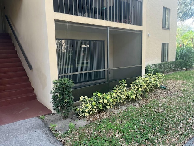 view of side of property with stucco siding and stairs