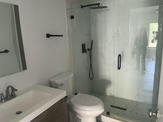 full bathroom featuring toilet, a marble finish shower, and vanity