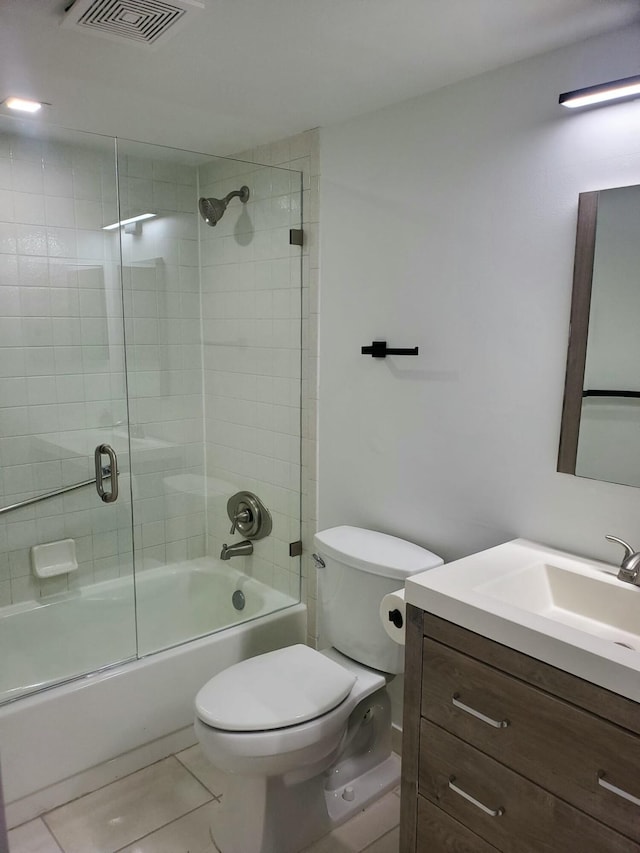 full bathroom featuring tile patterned floors, vanity, bath / shower combo with glass door, and toilet