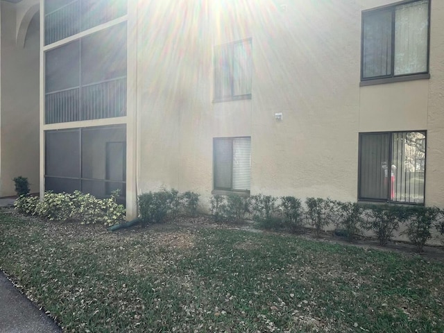 view of side of property with a yard and stucco siding