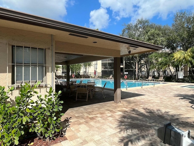 community pool featuring a patio area and fence