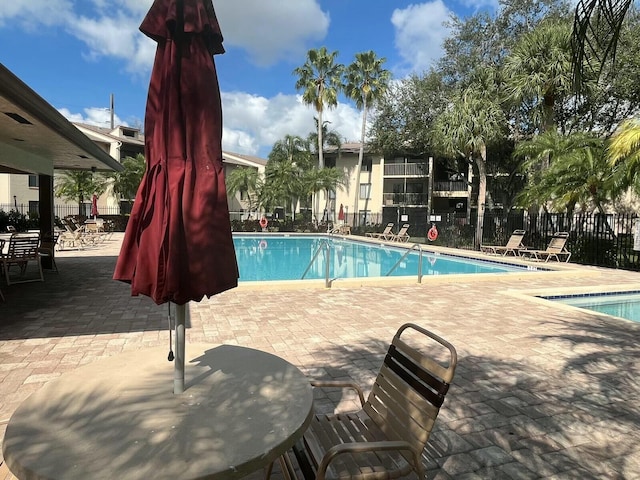 community pool featuring a patio area and fence