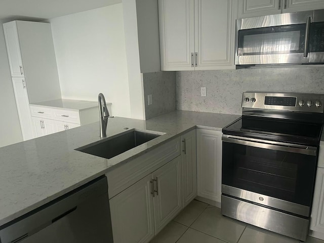 kitchen featuring white cabinetry, appliances with stainless steel finishes, and light stone counters