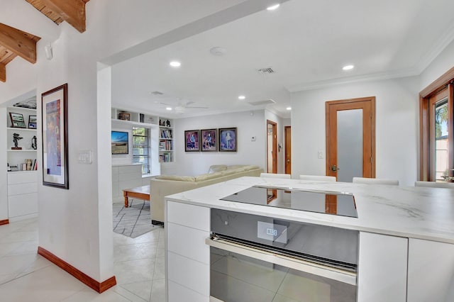 kitchen featuring stainless steel oven, built in shelves, ceiling fan, black electric cooktop, and white cabinetry