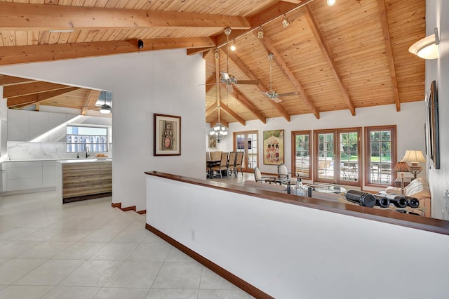 interior space with beamed ceiling, plenty of natural light, wood ceiling, and light tile patterned floors