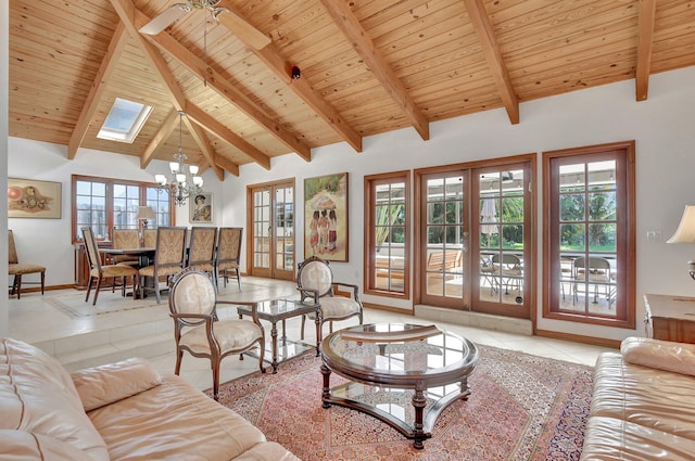 tiled living room with french doors, ceiling fan with notable chandelier, a skylight, beamed ceiling, and wood ceiling