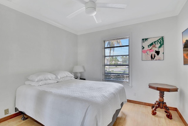 bedroom featuring hardwood / wood-style flooring, ceiling fan, and crown molding