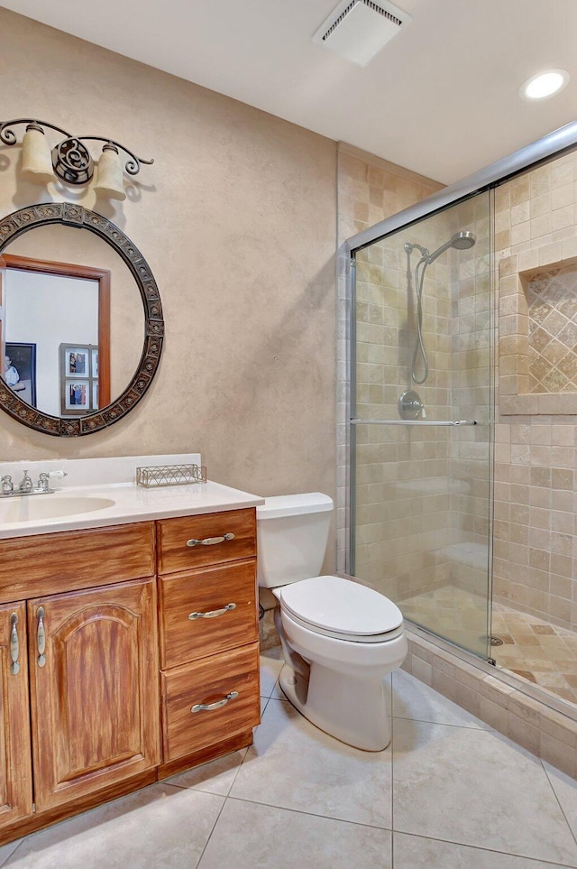 bathroom featuring toilet, vanity, tile patterned floors, and walk in shower