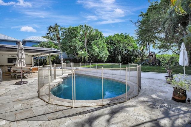 view of swimming pool featuring a playground and a patio