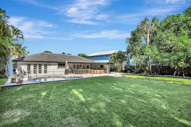 back of house featuring a fenced in pool, a patio area, a yard, and french doors