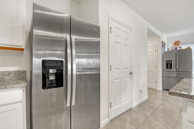 kitchen featuring white cabinetry, light stone countertops, stainless steel fridge, and high end refrigerator