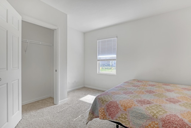 bedroom featuring light colored carpet and a closet