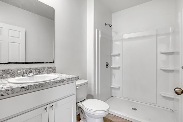 bathroom with vanity, tile patterned floors, a shower, and toilet