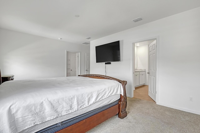 carpeted bedroom featuring ensuite bath