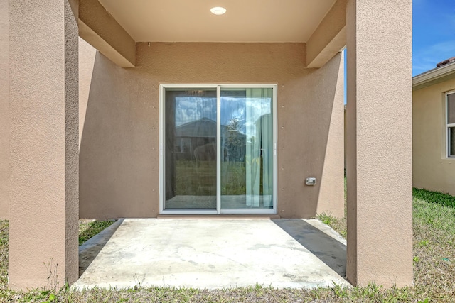 view of exterior entry featuring a patio