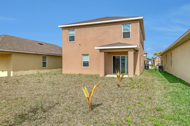 rear view of house featuring a yard