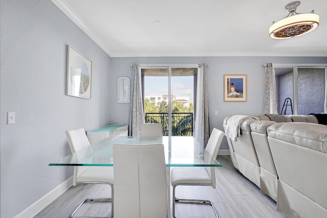 dining room featuring light wood-type flooring and crown molding