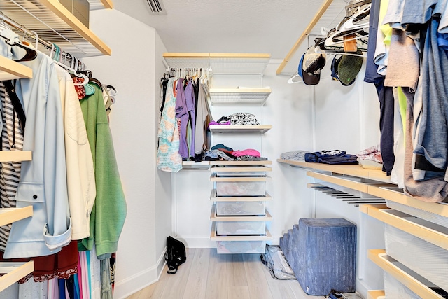 walk in closet with hardwood / wood-style floors