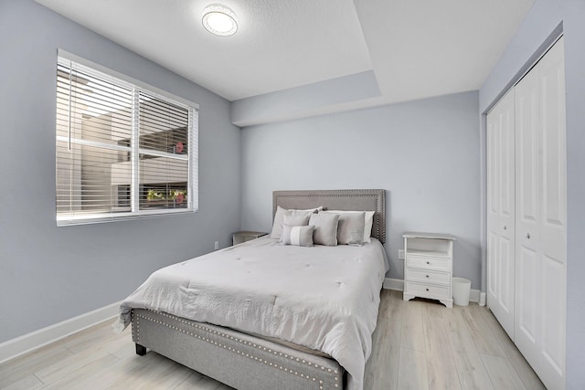 bedroom with light hardwood / wood-style flooring and a closet