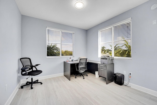 office with a healthy amount of sunlight and light hardwood / wood-style floors