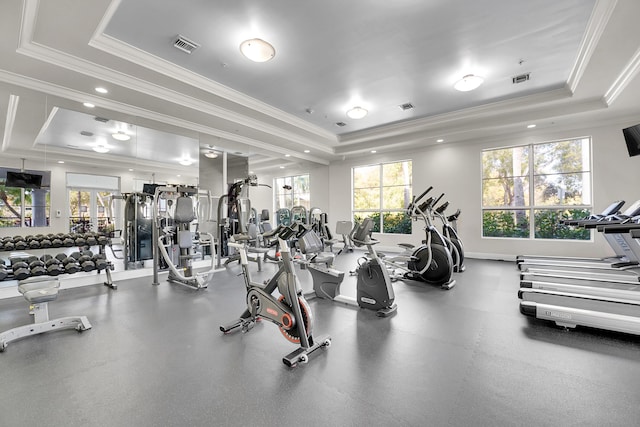 workout area with a raised ceiling and ornamental molding