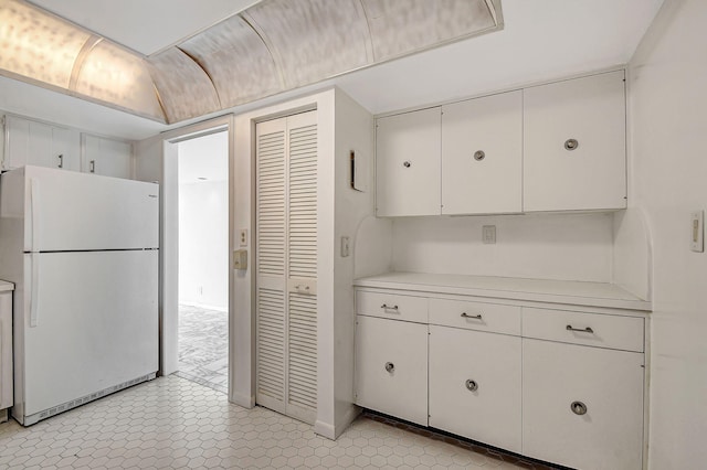 kitchen featuring white cabinets and white refrigerator