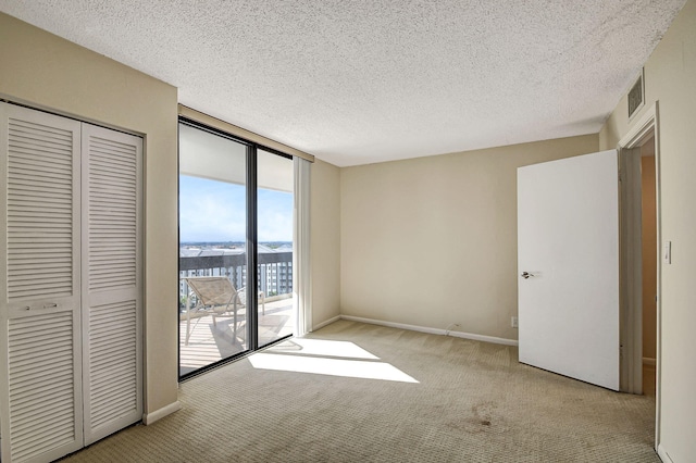 unfurnished bedroom featuring a textured ceiling, access to outside, and a closet