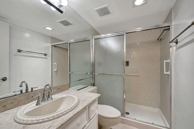 bathroom featuring vanity, an enclosed shower, and toilet