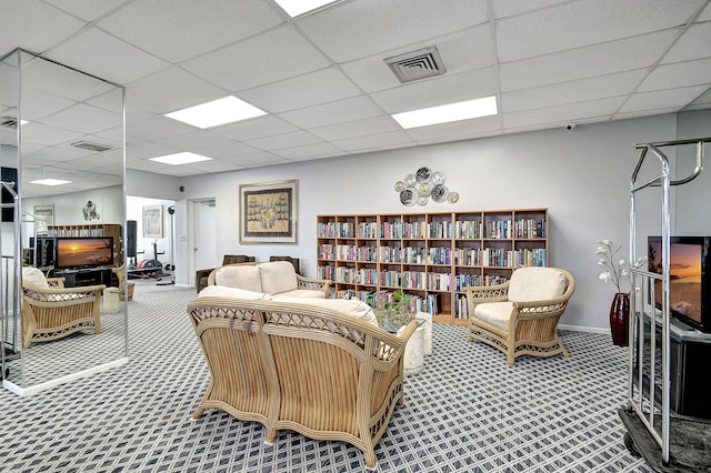 carpeted living room featuring a paneled ceiling