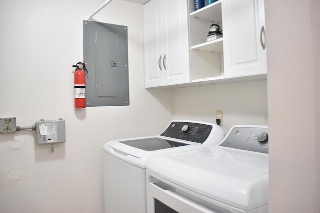 laundry room featuring electric panel, cabinet space, and separate washer and dryer